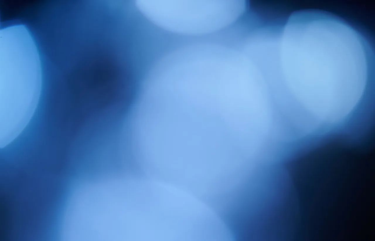 Overlapping out of focus blue light circles forming a soft abstract pattern