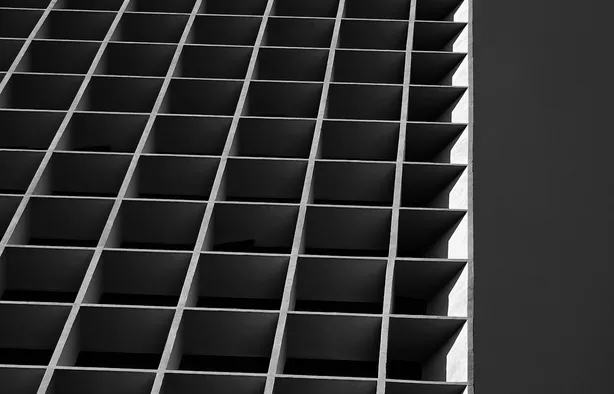 Repeating rectangular panels on a modern facade casting ordered shadows