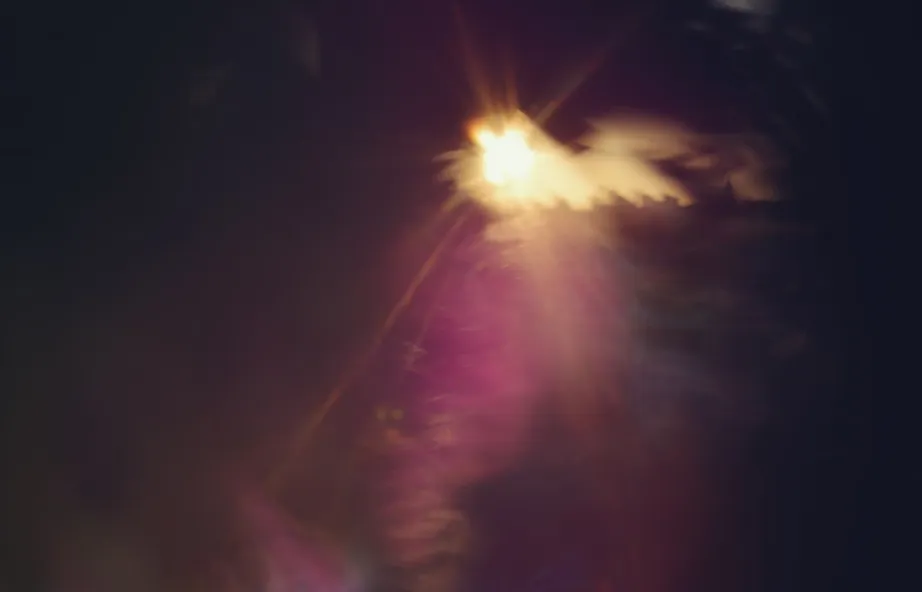 Red and violet light rays converging toward a single bright point on black